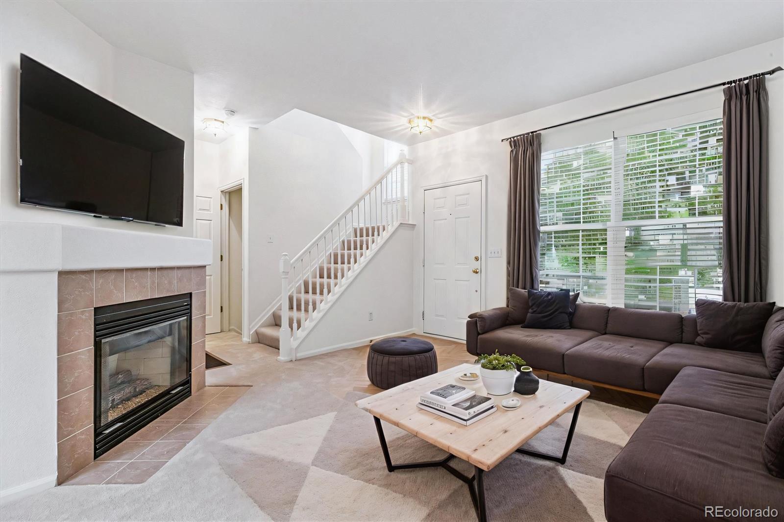 260 West Jamison Circle, Unit 13 Littleton, CO 80120 - Photo 5 of 24 a living room with furniture a flat screen tv and a fireplace