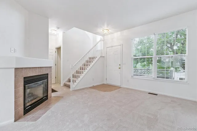 a view of empty room with fireplace and windows