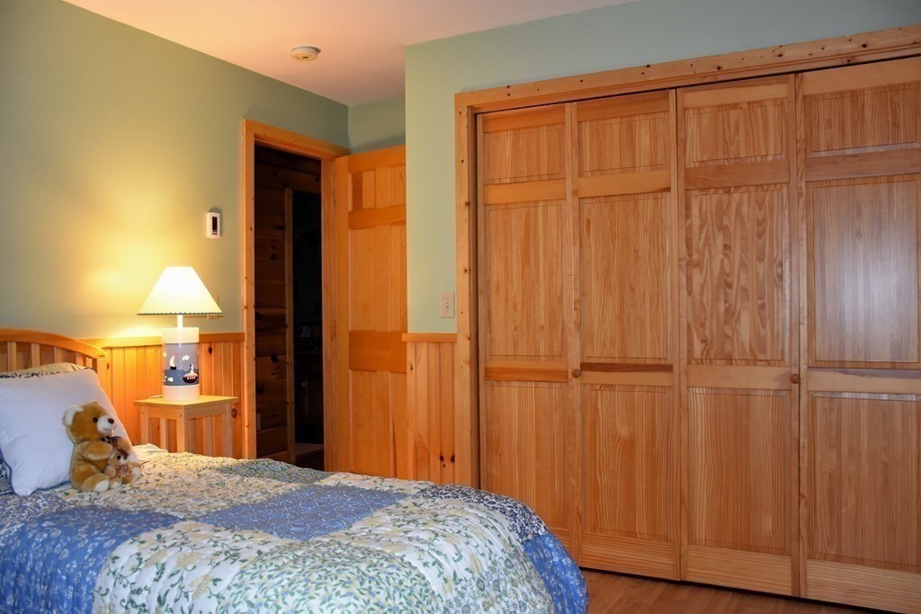 145 Baker Pond Road Dudley, MA 01571 - Photo 21 of 27 a bedroom with a bed and a lamp