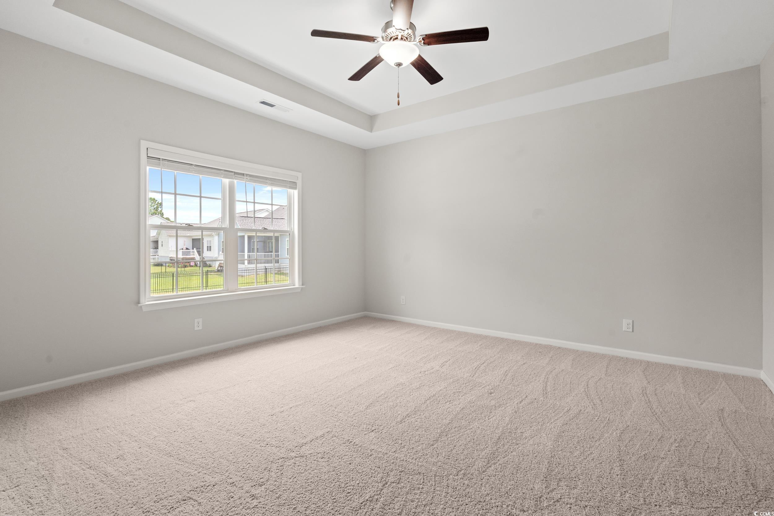 512 Charlton Boulevard Georgetown, SC 29440 - Photo 11 of 35 Spare room with a tray ceiling, baseboards, light colored carpet, and ceiling fan