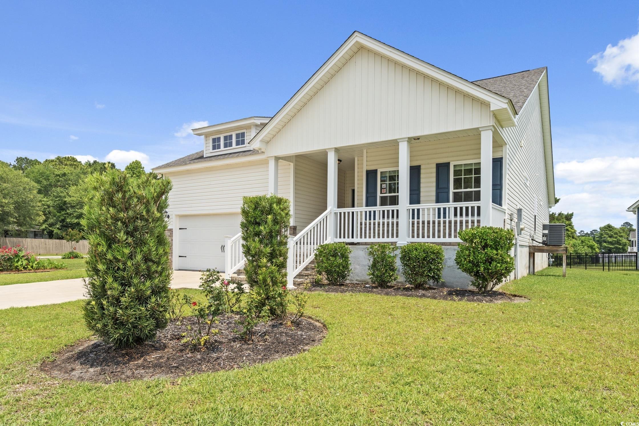 512 Charlton Boulevard Georgetown, SC 29440 - Photo 2 of 35 View of front of home with covered porch, a shingled roof, concrete driveway, a garage, and cooling unit