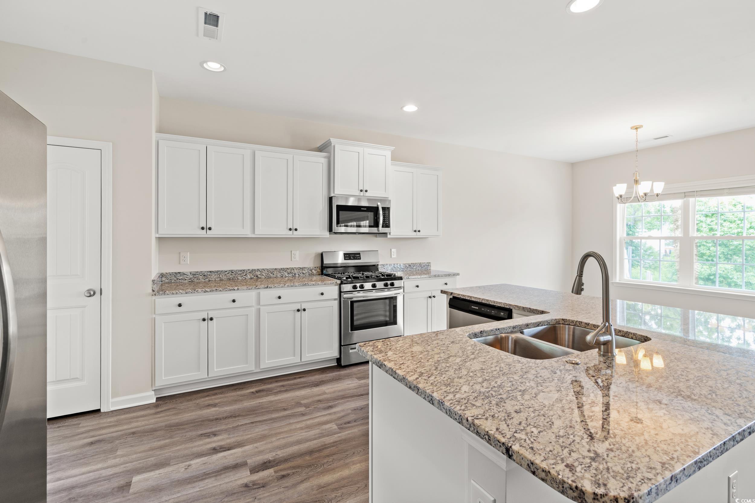 512 Charlton Boulevard Georgetown, SC 29440 - Photo 5 of 35 Kitchen with appliances with stainless steel finishes, a sink, light wood finished floors, white cabinetry, and recessed lighting