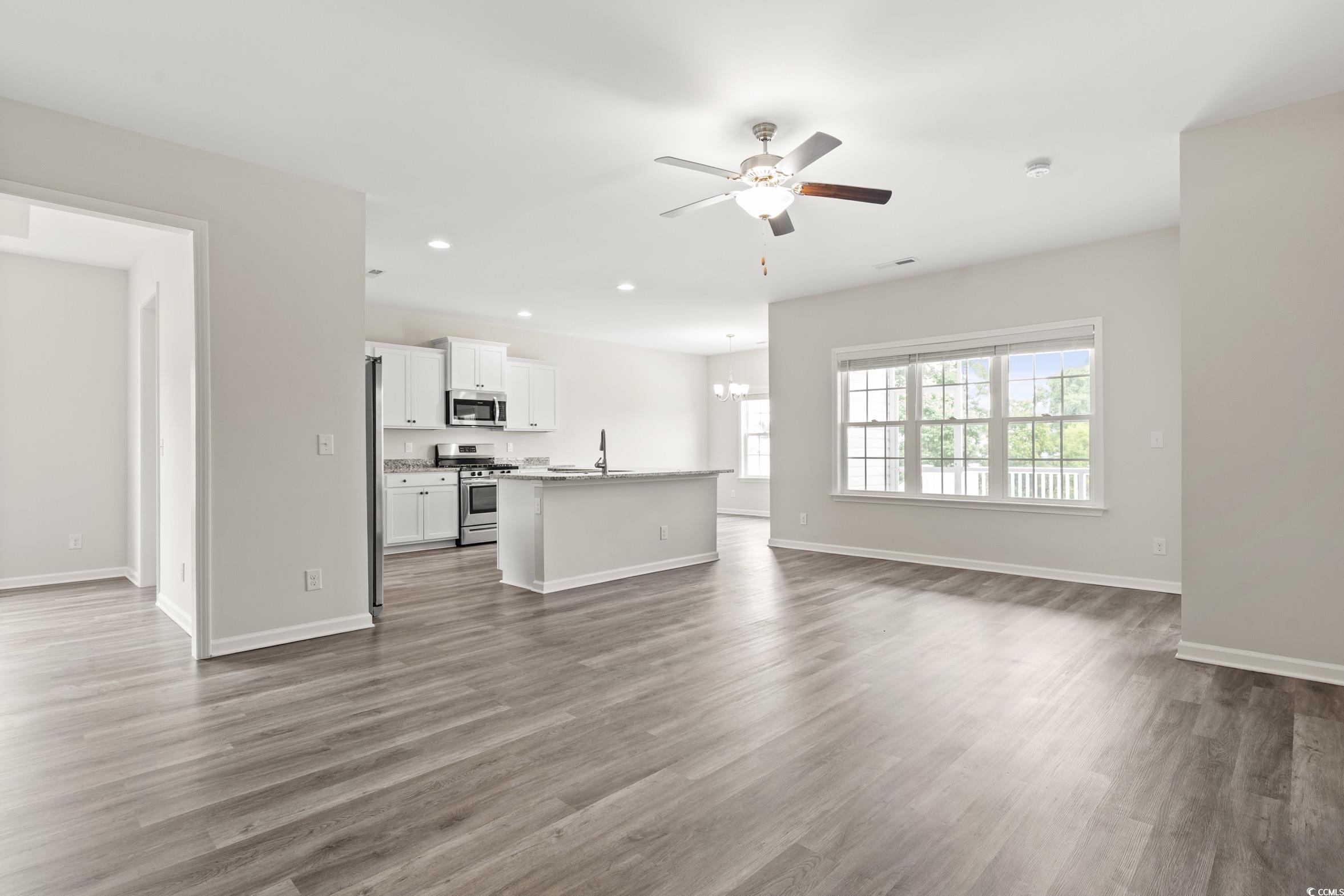 512 Charlton Boulevard Georgetown, SC 29440 - Photo 7 of 35 Unfurnished living room with a ceiling fan, dark wood finished floors, recessed lighting, baseboards, and a chandelier