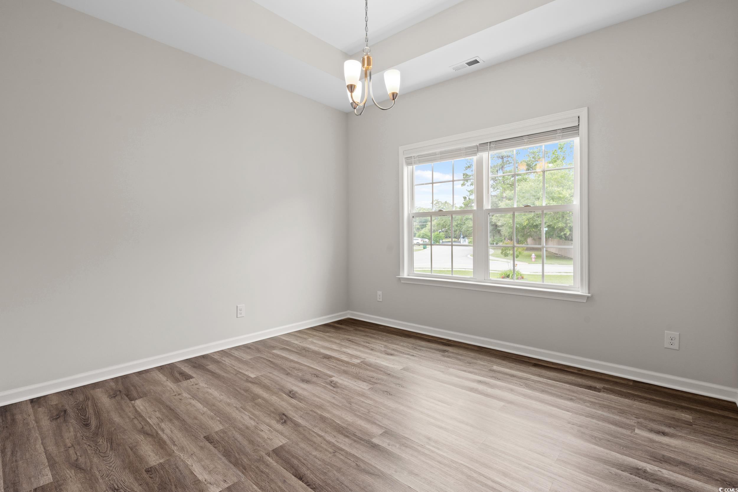 512 Charlton Boulevard Georgetown, SC 29440 - Photo 8 of 35 Spare room featuring wood finished floors, a chandelier, and baseboards