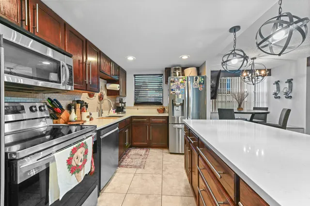 a kitchen with stainless steel appliances granite countertop a sink stove and microwave