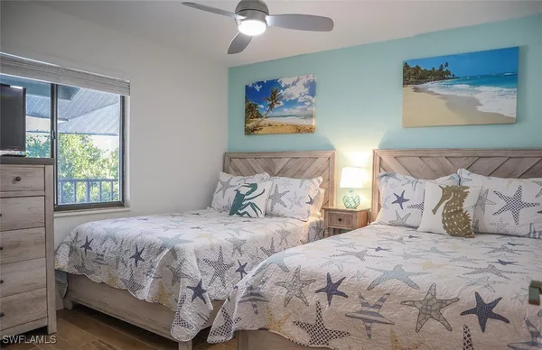 a bedroom with two beds and a painting on the wall