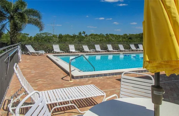 a view of swimming pool with seating area and lake view