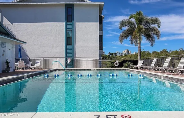 a view of swimming pool with outdoor seating and house in the background