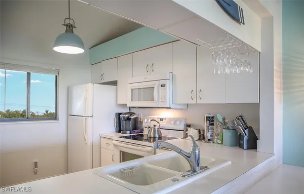 a kitchen with stainless steel appliances granite countertop a refrigerator sink and stove