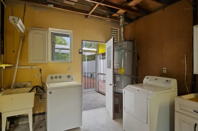 an empty room with wooden floor chandelier fan and windows