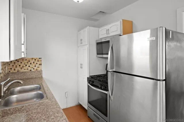 an empty room with wooden floor closet and fan