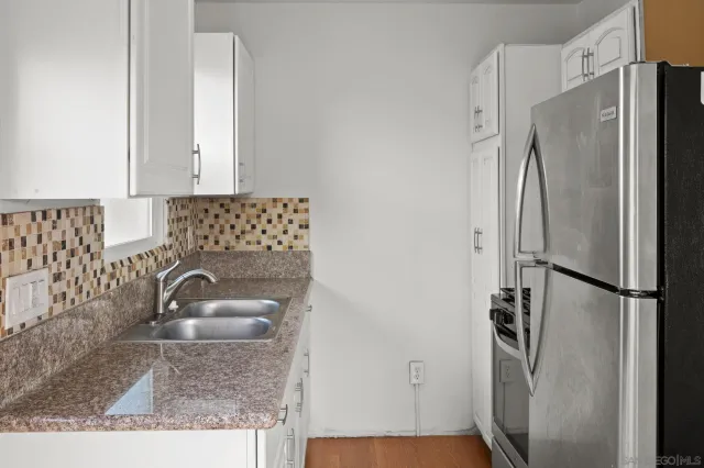 a view of empty room with wooden floor and ceiling fan