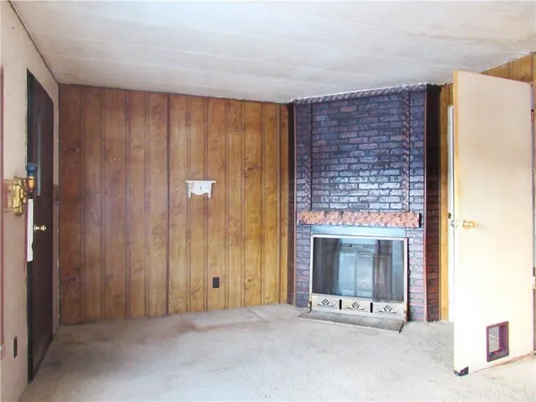 a view of an empty room with a fireplace and a window
