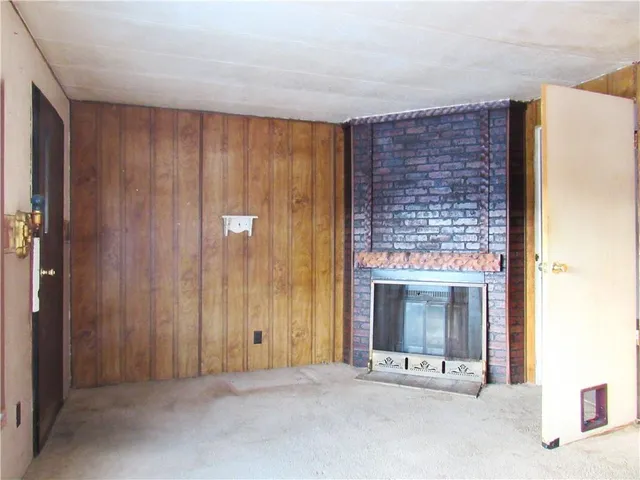 a view of an empty room with a fireplace and a window