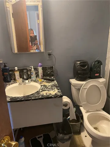 a bathroom with a granite countertop toilet sink and mirror