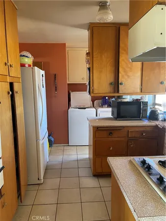a kitchen with a refrigerator and a stove top oven