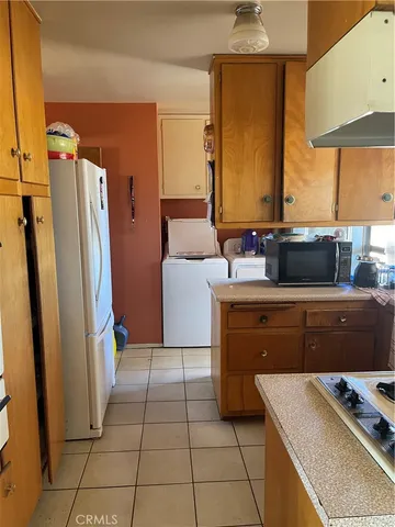 a kitchen with a refrigerator and a stove top oven