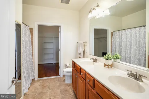 a bathroom with a double vanity sink mirror and shower