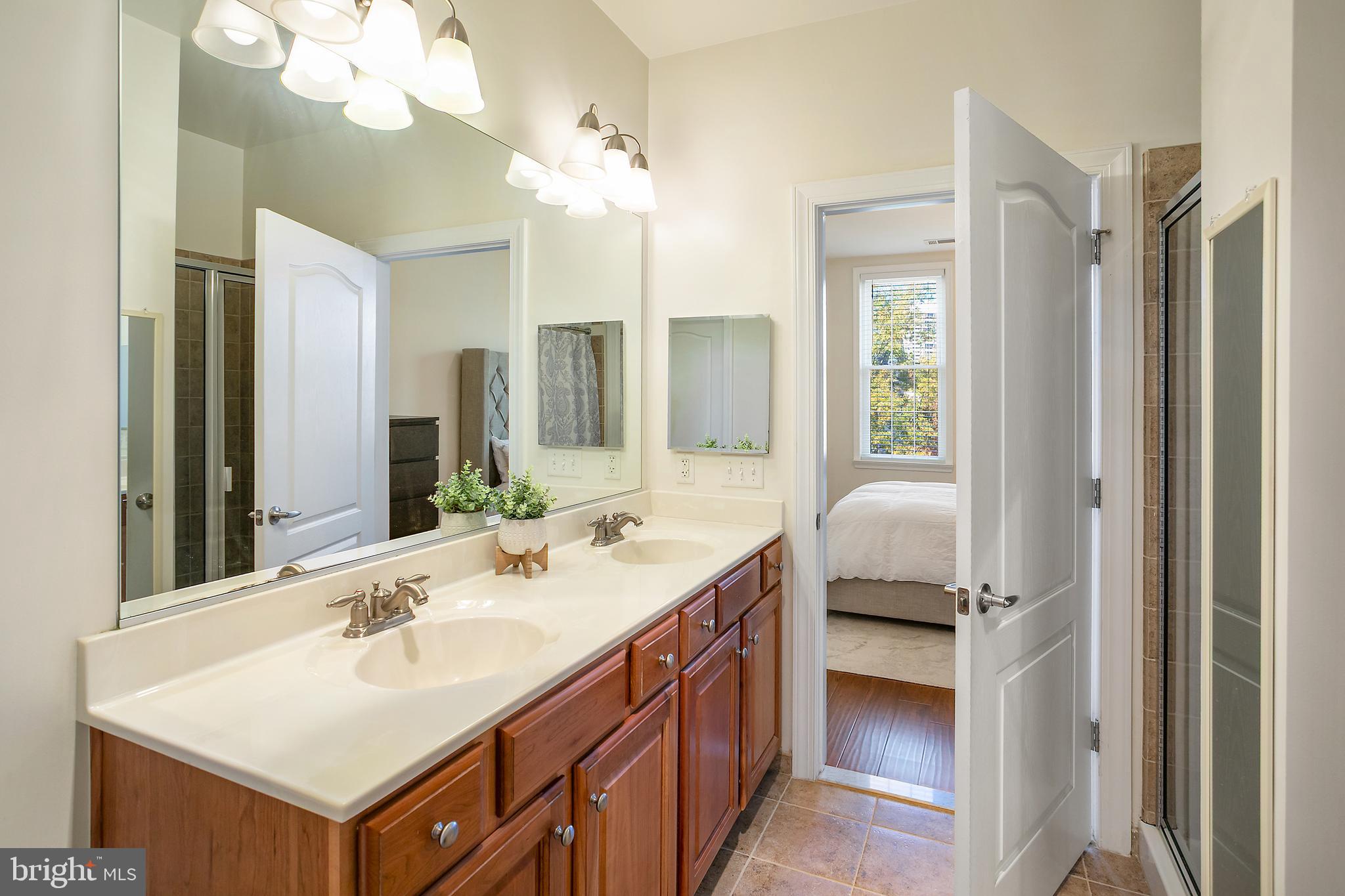 400 Cameron Station Boulevard, Unit 308 Alexandria, VA 22304 - Photo 12 of 46 a en suite bathroom with a sink double vanity and a mirror