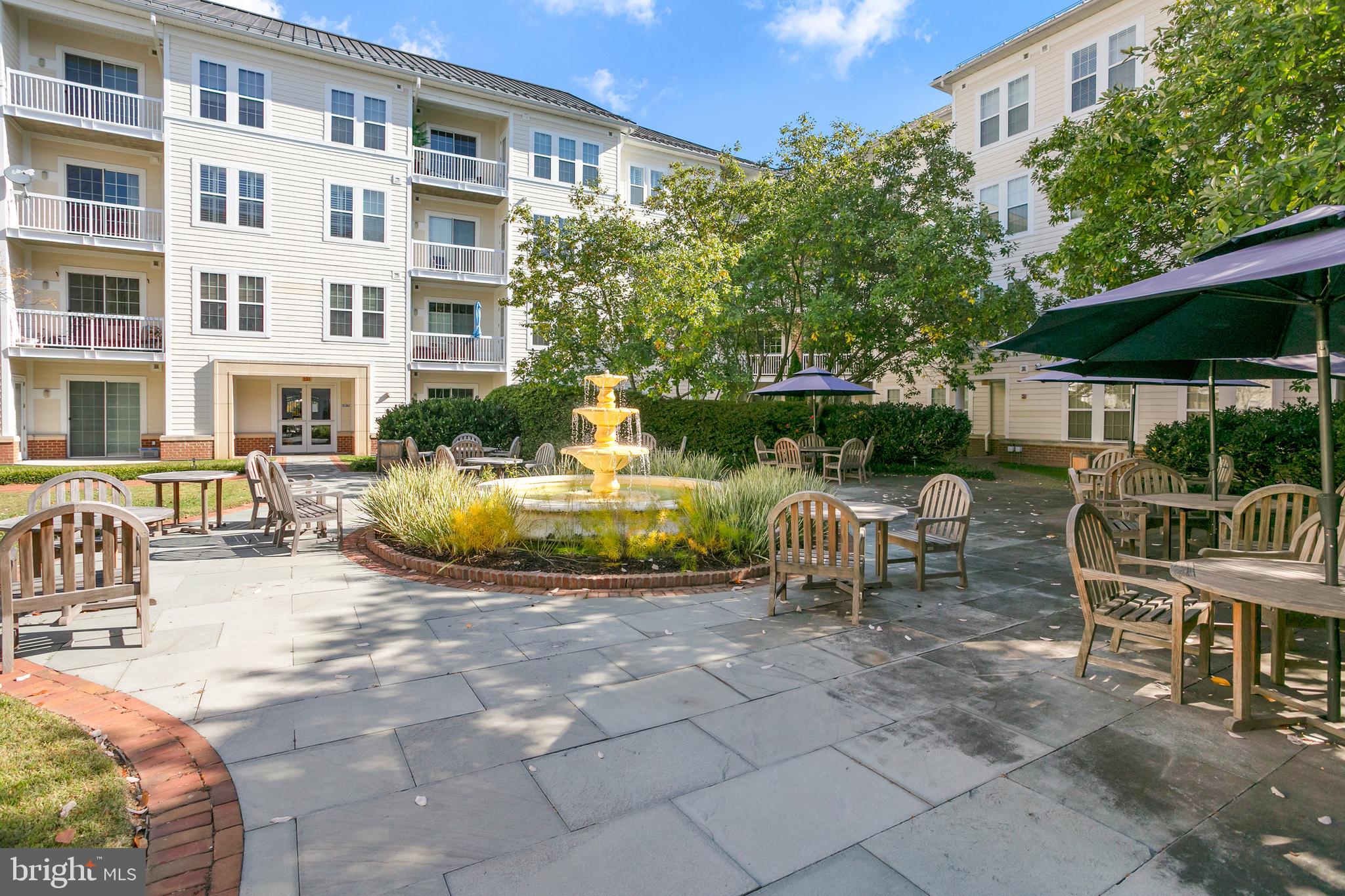 400 Cameron Station Boulevard, Unit 308 Alexandria, VA 22304 - Photo 24 of 46 a view of a patio with table and chairs under an umbrella