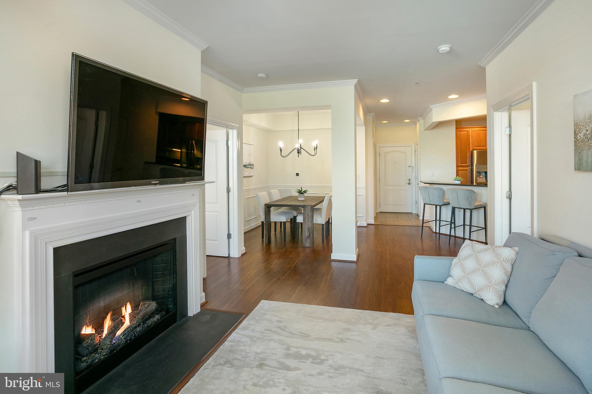 400 Cameron Station Boulevard, Unit 308 Alexandria, VA 22304 - Photo 5 of 46 a living room with furniture a flat screen tv and a fireplace