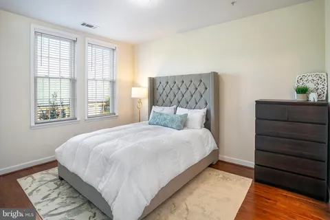 a large bed sitting in a bedroom next to a window with a dresser