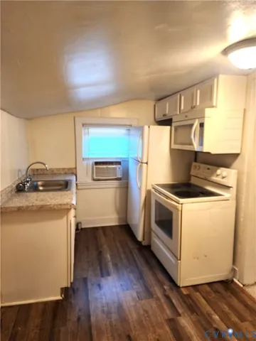 a kitchen with a stove and wooden floor