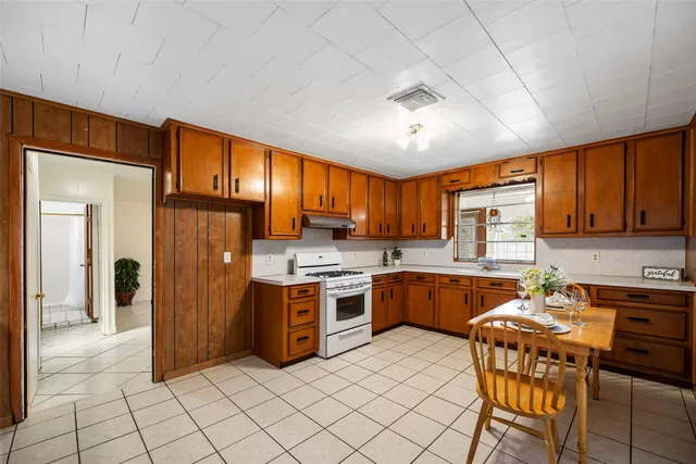 a kitchen with granite countertop cabinets a sink a dining table and chairs