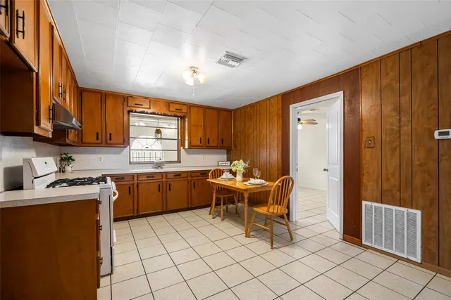 a kitchen with stainless steel appliances granite countertop a stove refrigerator and cabinets