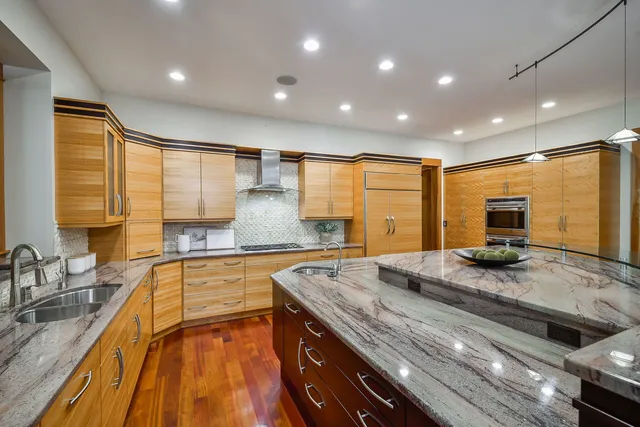 a kitchen with granite countertop stainless steel appliances a sink and cabinets