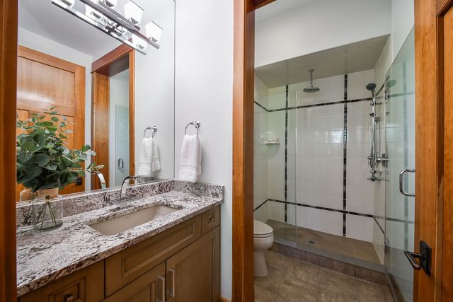 a bathroom with a granite countertop sink and a mirror