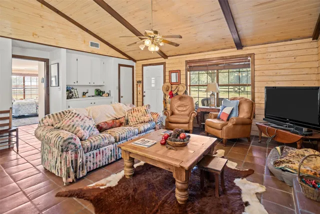 a living room with furniture a flat screen tv and a window