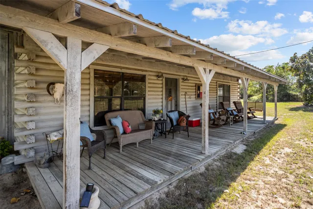 a view of a patio with table and chairs potted plants with wooden floor and fence