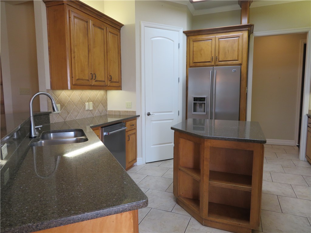 5803 South Oso Parkway Corpus Christi, TX 78414 - Photo 13 of 39 a kitchen with granite countertop stainless steel appliances and wooden cabinets