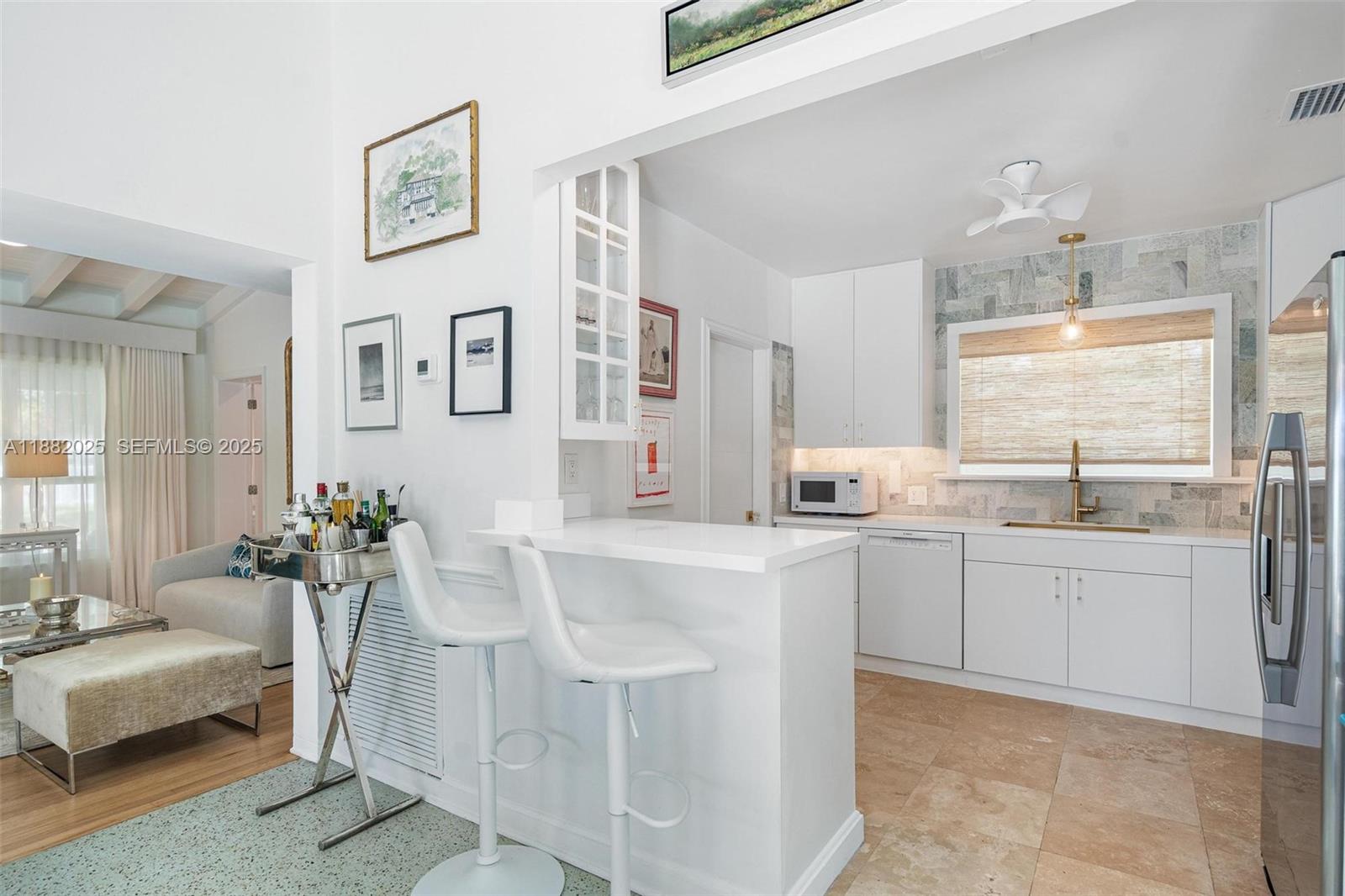 9357 Northeast 9th Place Miami Shores, FL 33138 - Photo 13 of 51 a large white kitchen with cabinets and chairs