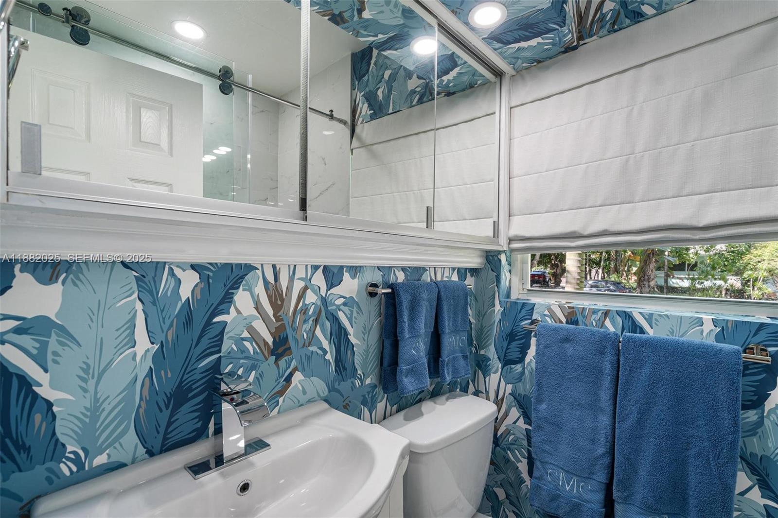 9357 Northeast 9th Place Miami Shores, FL 33138 - Photo 24 of 51 a bathroom with a toilet sink and mirror