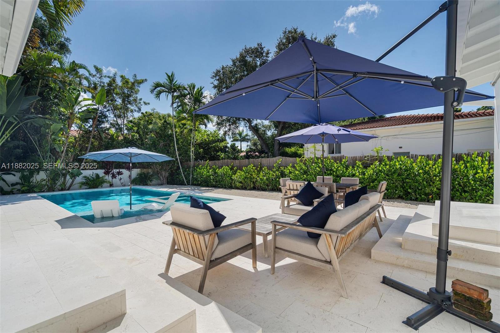 9357 Northeast 9th Place Miami Shores, FL 33138 - Photo 32 of 51 a view of patio with table and chairs under an umbrella