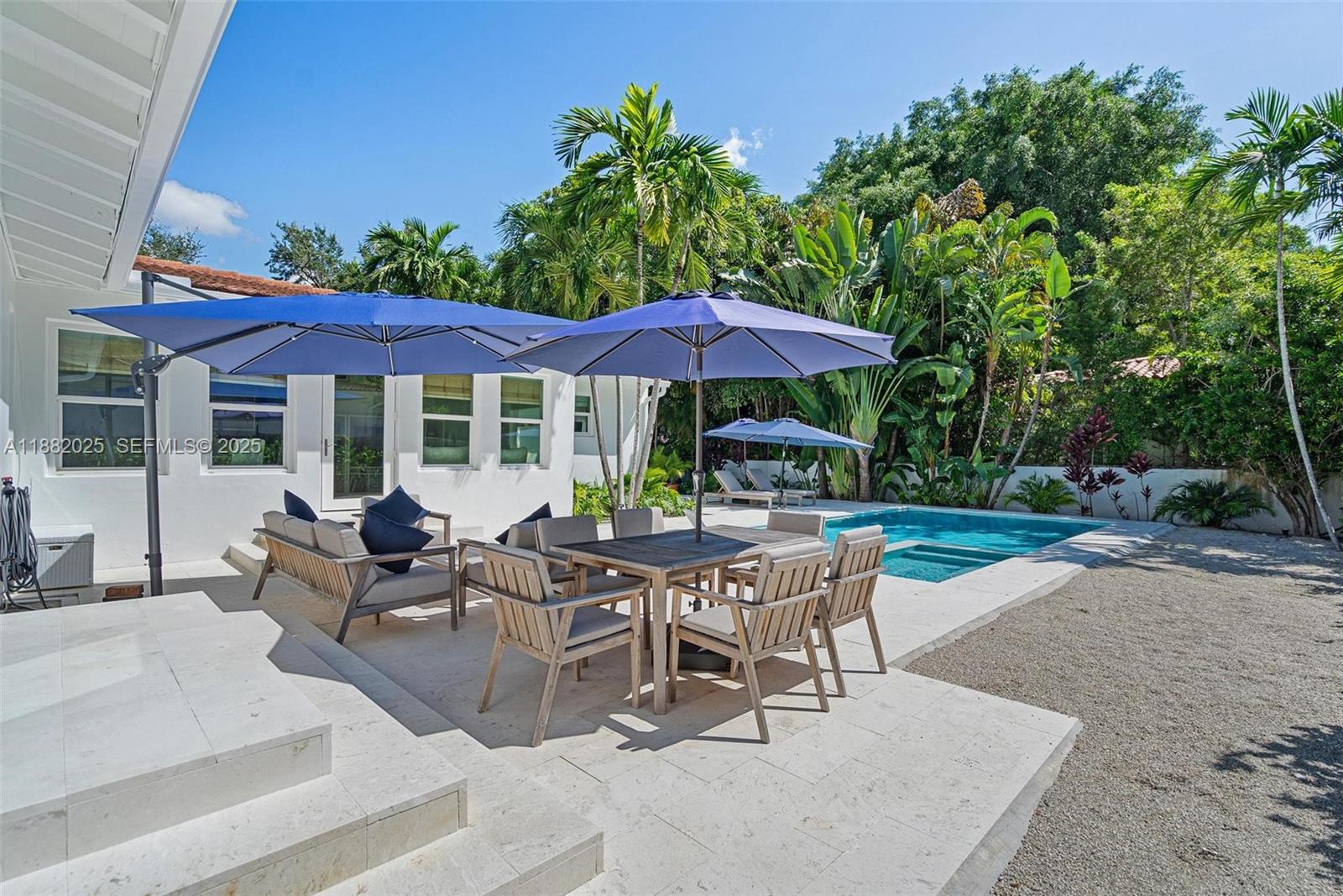 9357 Northeast 9th Place Miami Shores, FL 33138 - Photo 33 of 51 a view of patio with chairs and table under an umbrella