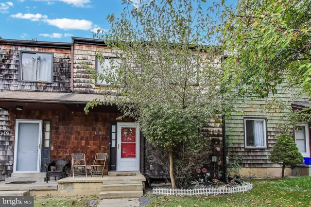 a front view of a house with a tree