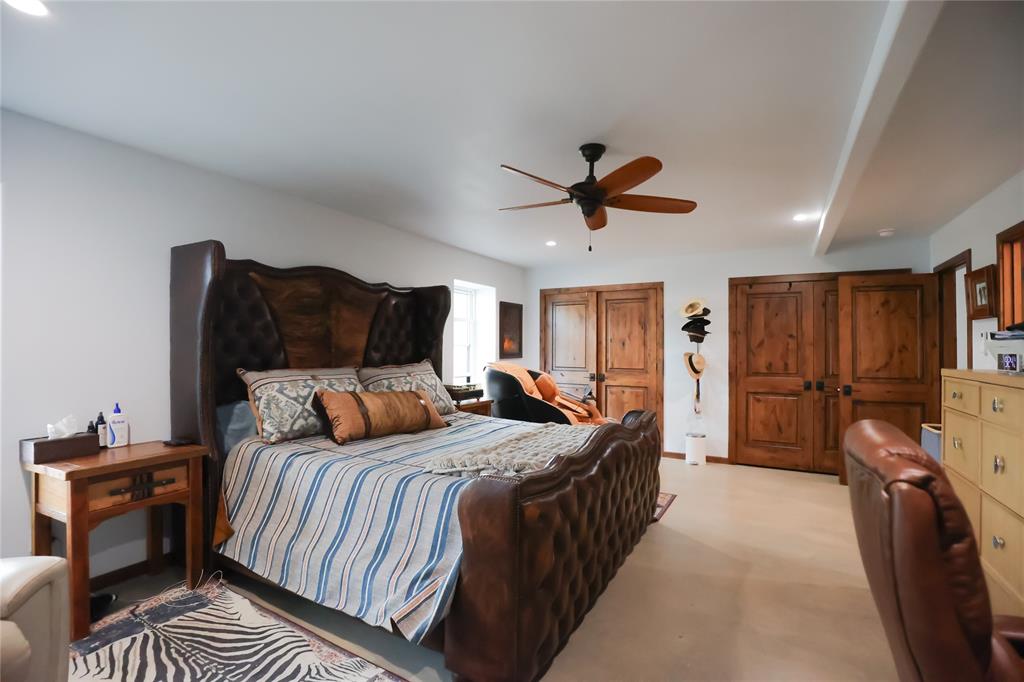 1250 County Road Brady, TX 76825 - Photo 12 of 40 a bedroom with a bed a dresser and a chandelier