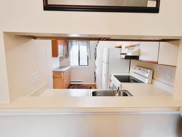a view of kitchen with furniture and refrigerator