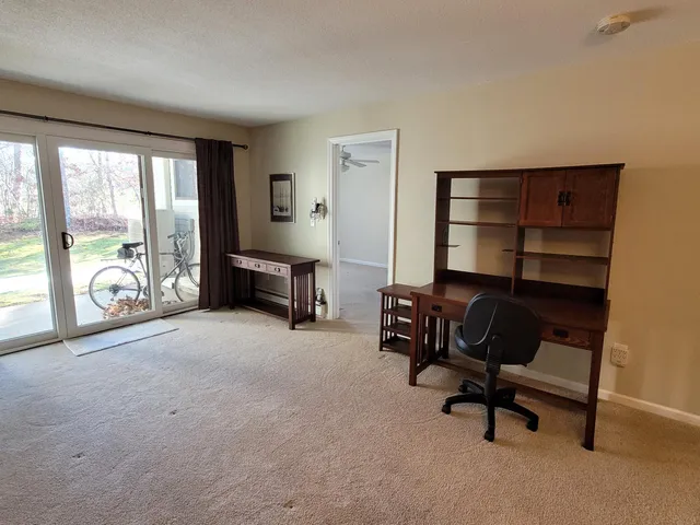a view of a livingroom with workspace and a window