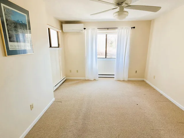 an empty room with a ceiling fan and window
