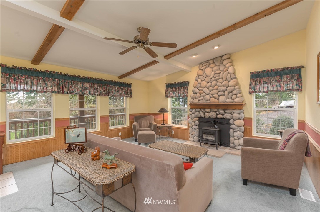 18109 Thorsen Road Southwest Vashon, WA 98070 - Photo 13 of 37 a living room with furniture a fireplace and a large window