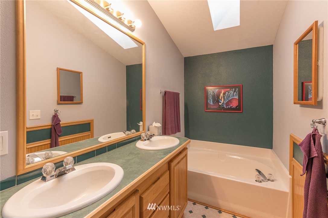 18109 Thorsen Road Southwest Vashon, WA 98070 - Photo 20 of 37 a bathroom with a granite countertop tub sink and mirror