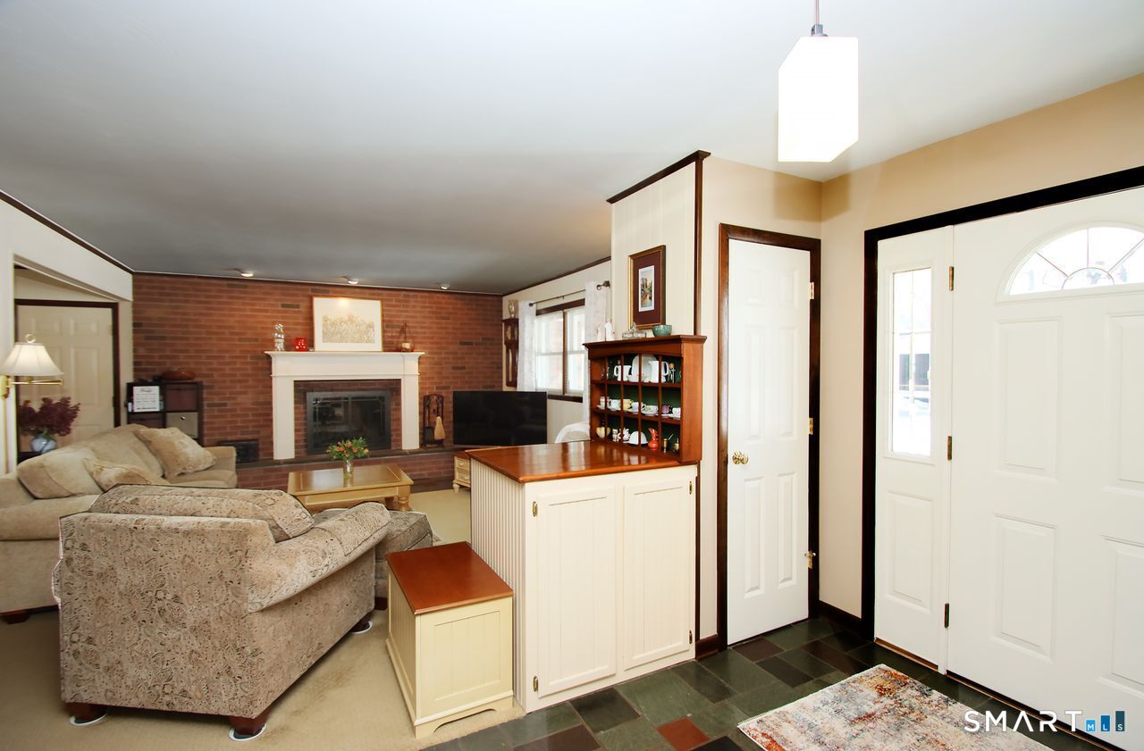 7 Old Forge Road North Haven, CT 06473 - Photo 6 of 40 a living room with furniture a fireplace and a chandelier