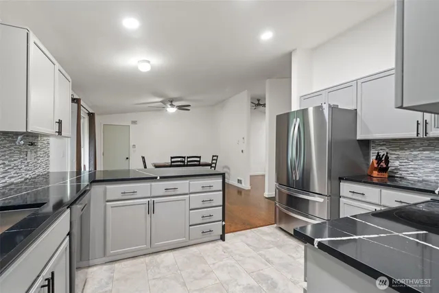 a kitchen with granite countertop a refrigerator and a sink
