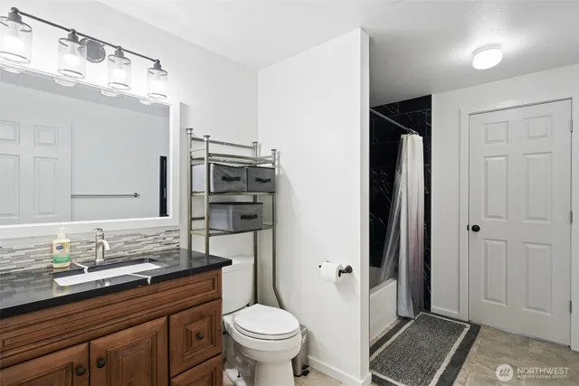 a bathroom with a granite countertop sink toilet and shower