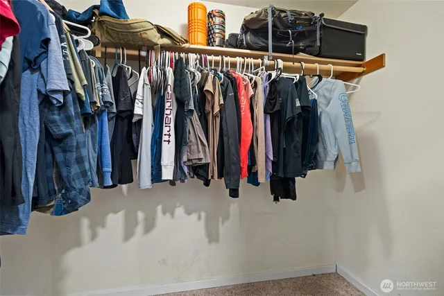 a view of walk in closet with clothes