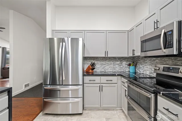 a kitchen with stainless steel appliances granite countertop a refrigerator and a stove